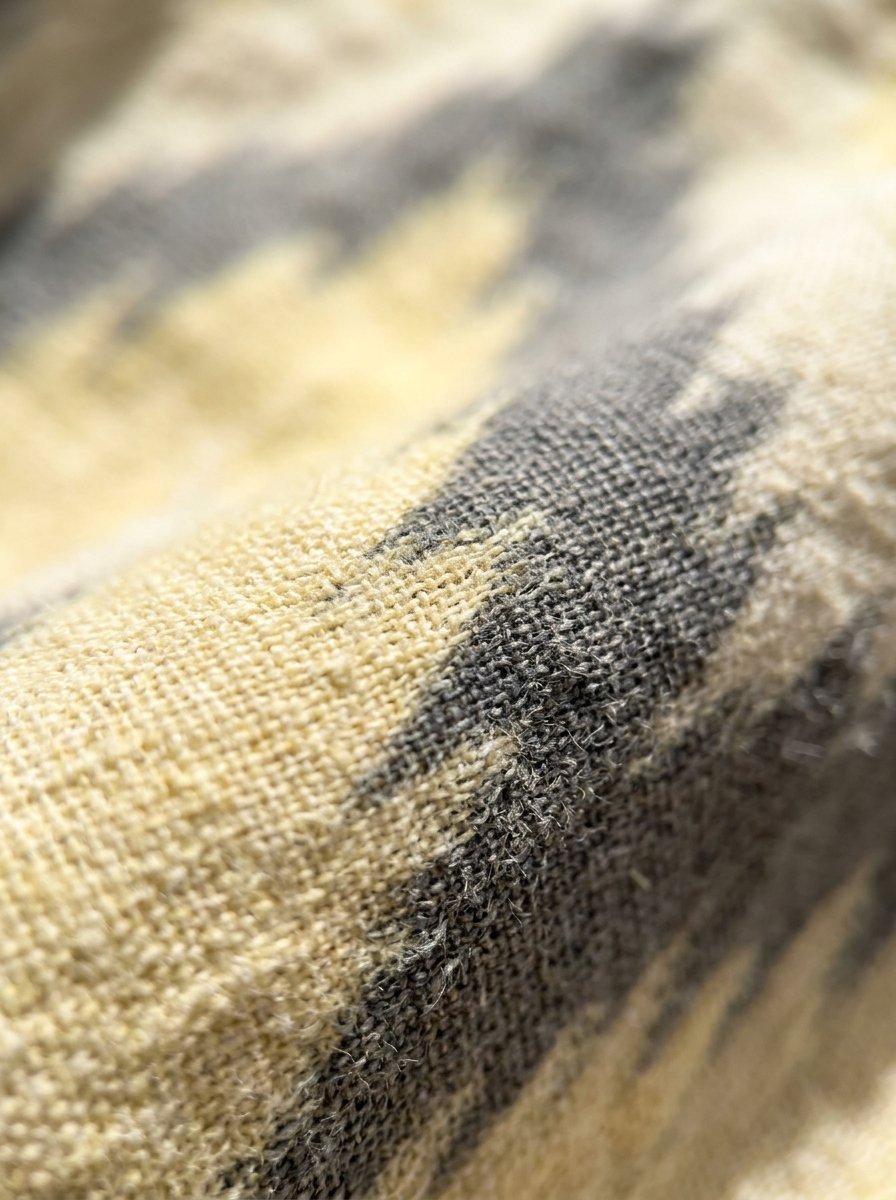 Extreme macro photography of fibrous grey and pale yellow textile weaves.