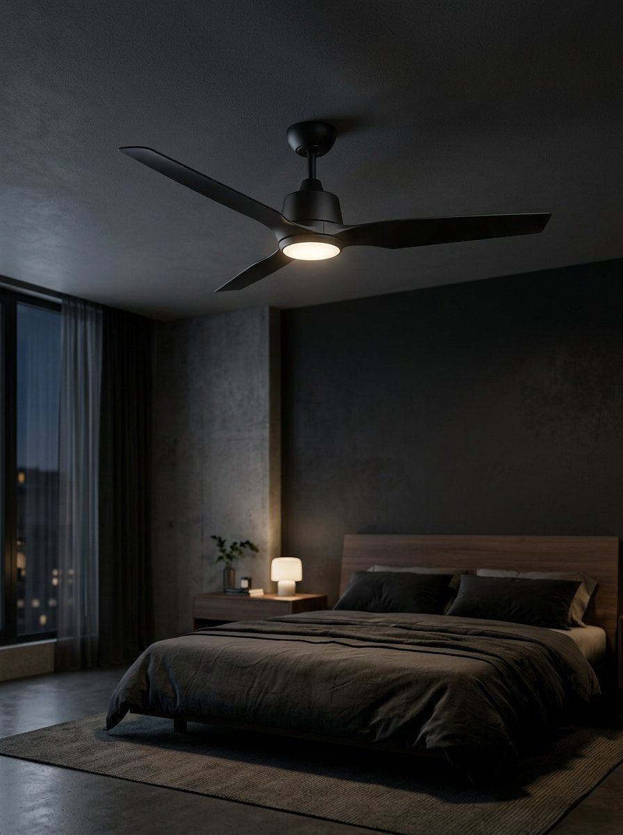 Modern three-blade black ceiling fan with an integrated light fixture in a dimly lit contemporary master bedroom.