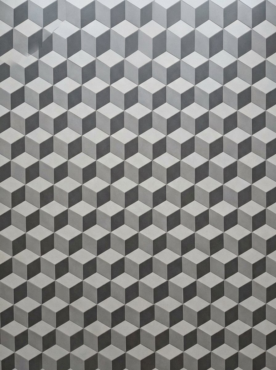 A repeating three-dimensional pattern of grey and black cubes creating an optical depth effect.