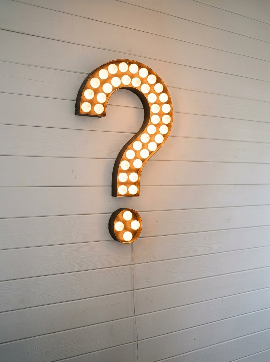 Glowing question mark light fixture mounted on a white wooden plank wall.